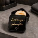 Schwarze personalisierte Aufbewahrungsdose für Shampoo-Bars mit goldener Aufschrift „Lieblingsmensch“, gefüllt mit einem handgemachten Naturleise Shampoo-Bar mit Kamille und Ringelblume.